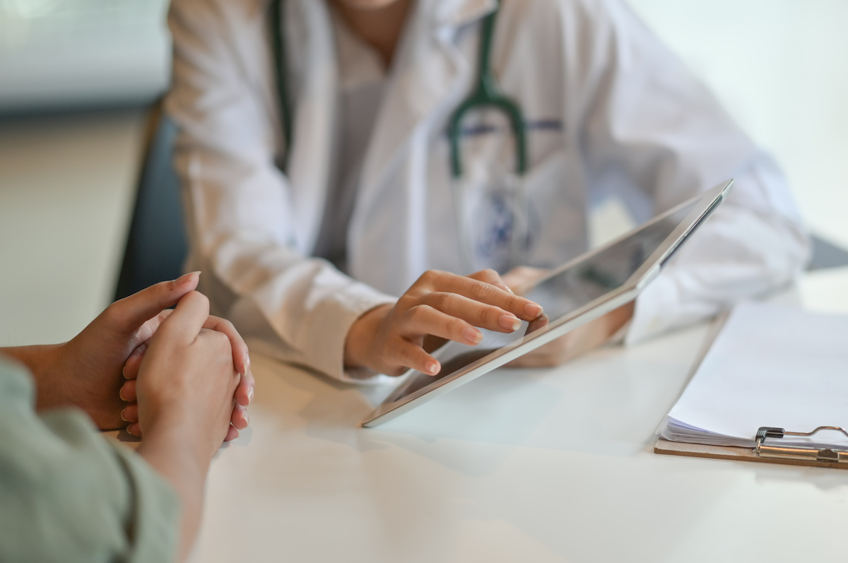Shot of a doctor showing a patient some information on a digital tablet